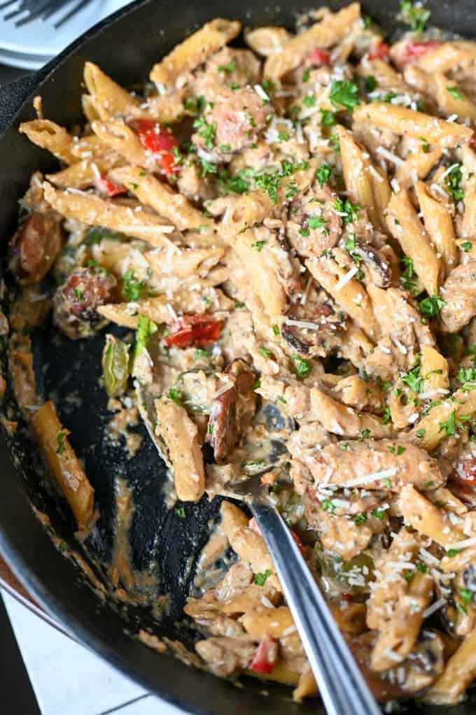 A close-up of chicken and pasta in a skillet.