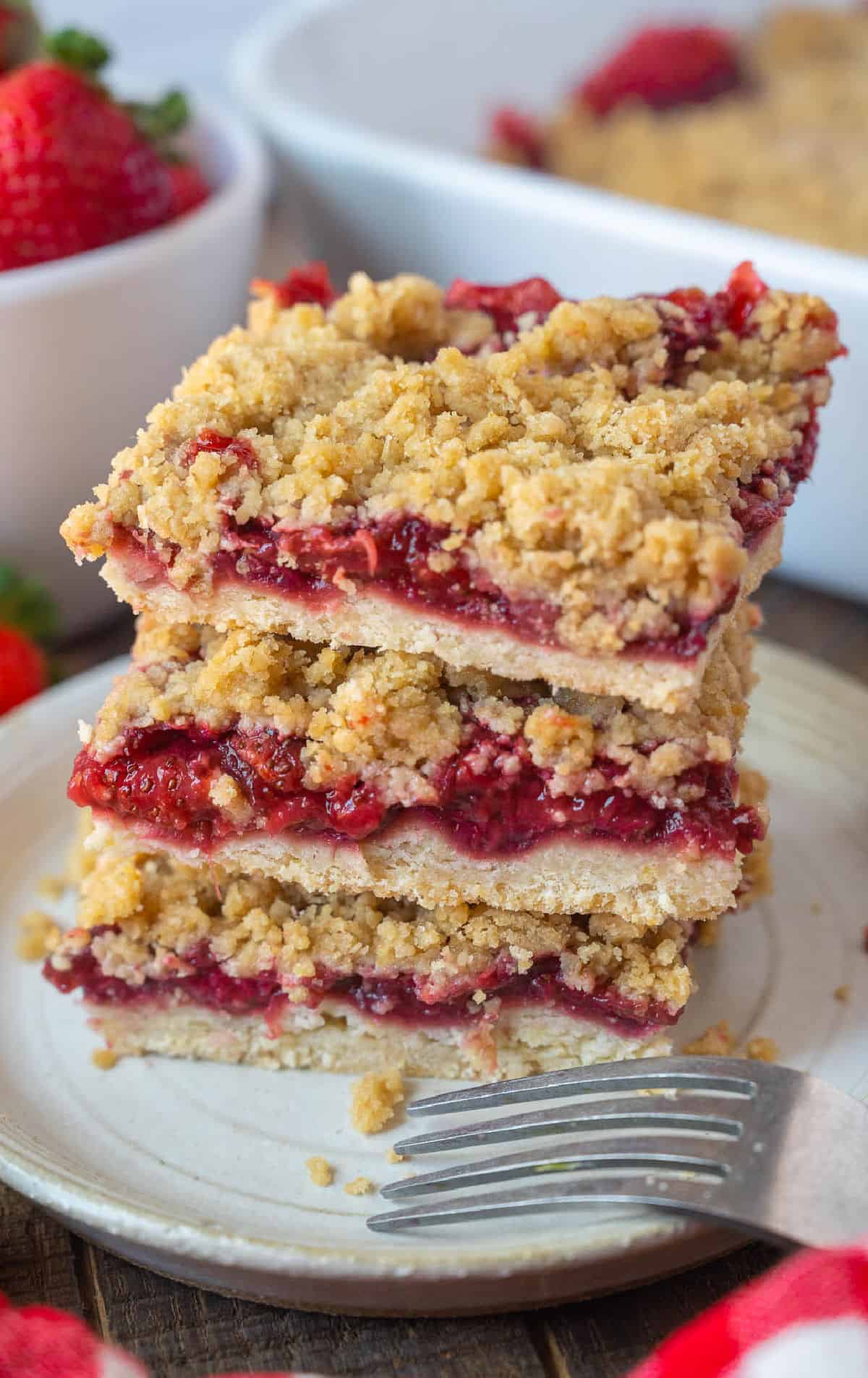 Three strawberry bars stacked on a plate.