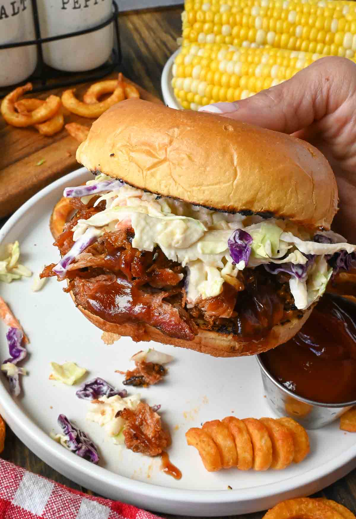 Pulled pork sandwich being picked up.