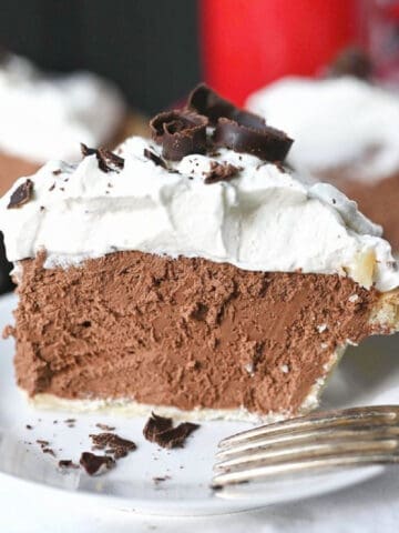A slice of chocolate cream pie on a white plate.