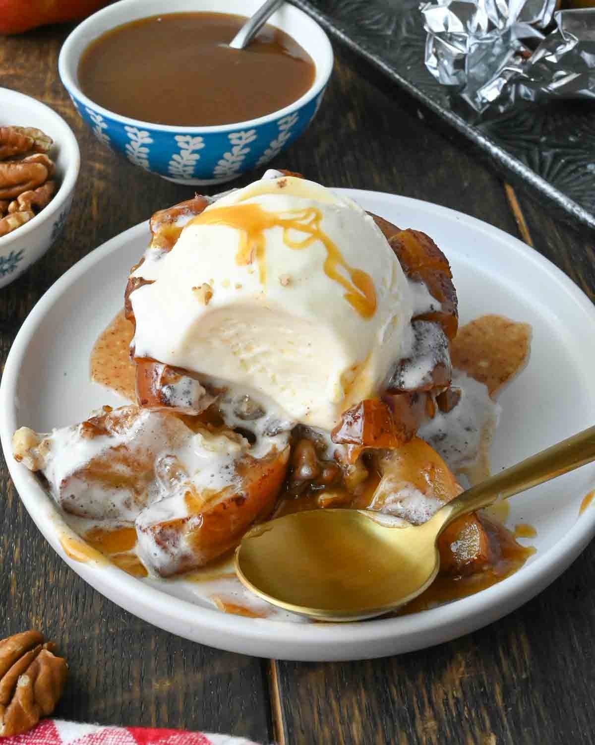 Grilled apple with vanilla ice cream and a spoon.
