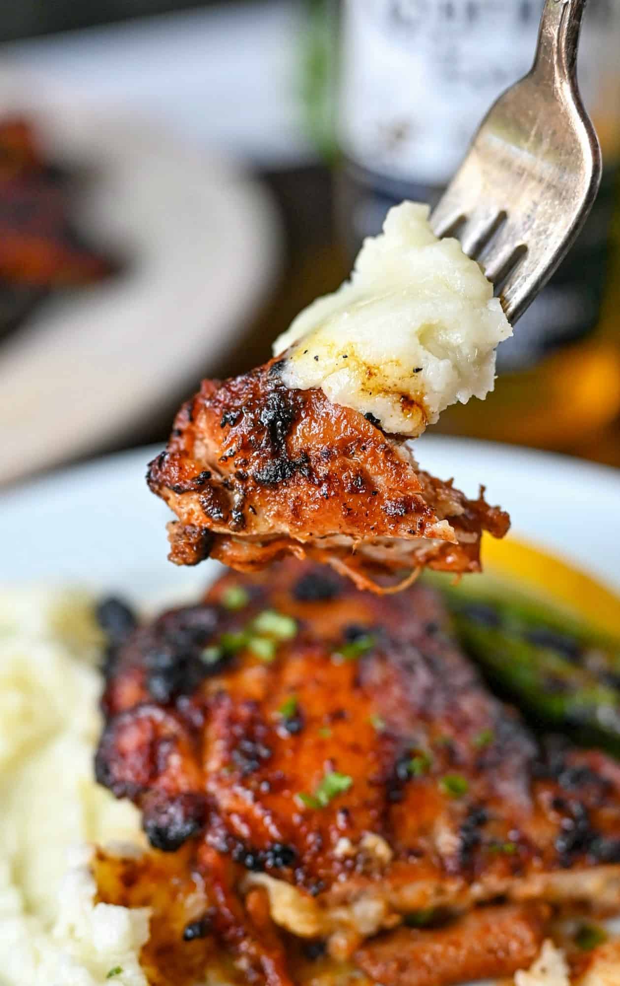 Sweet N Spicy chicken bute on a fork with mashed potatoes.