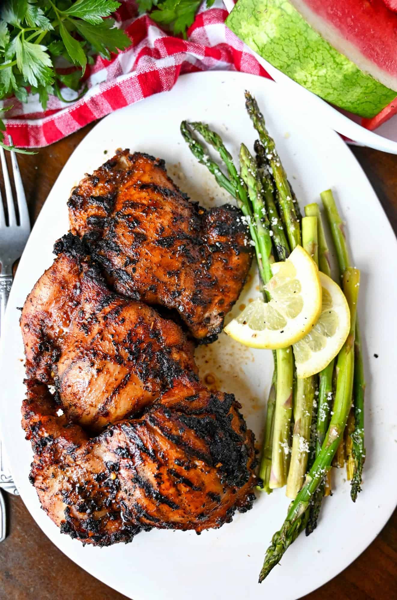 A plate of chicken thighs and asparagus.