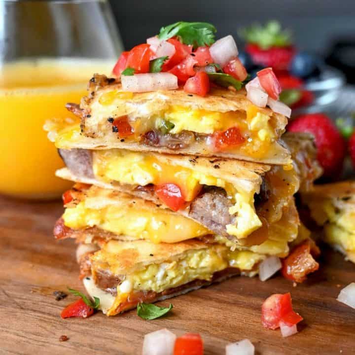 Breakfast quesadilla cut into fourths and stacked on top of each other with a pile of pico de gallo on top.
