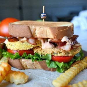 Fried green tomato BLT sandwich with special sauce. A side of crinkle cut french fries.