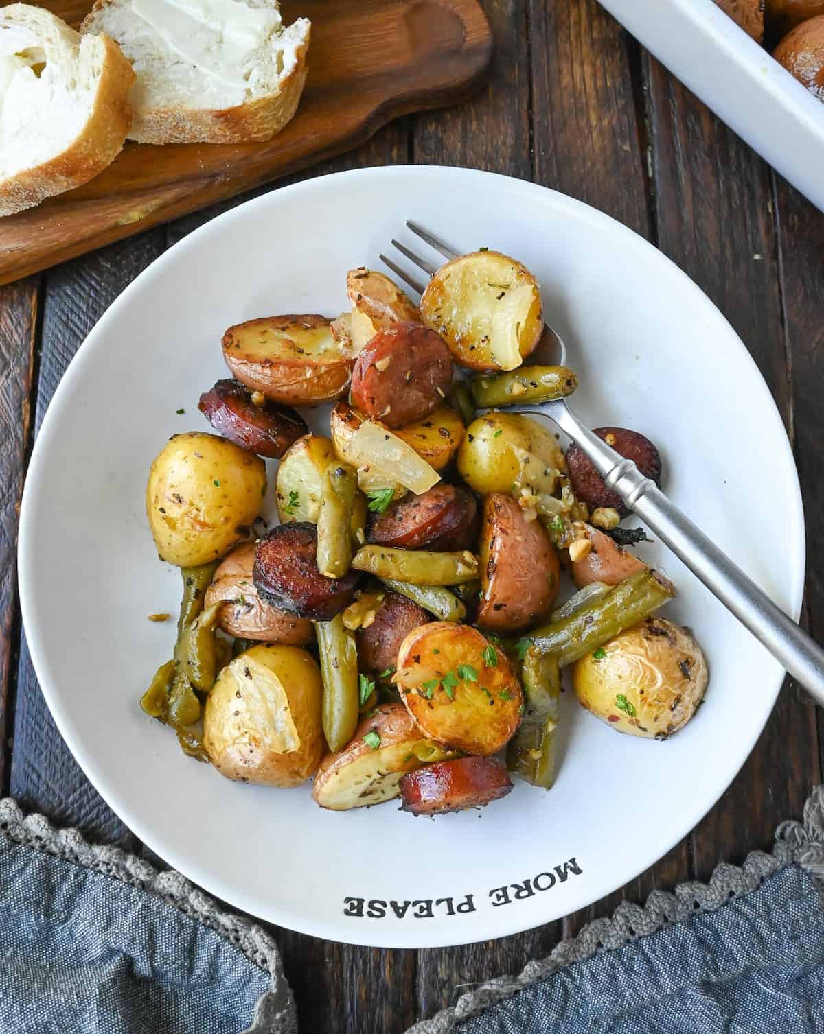 Sausage green beans and potatoes in a bowl with a fork.