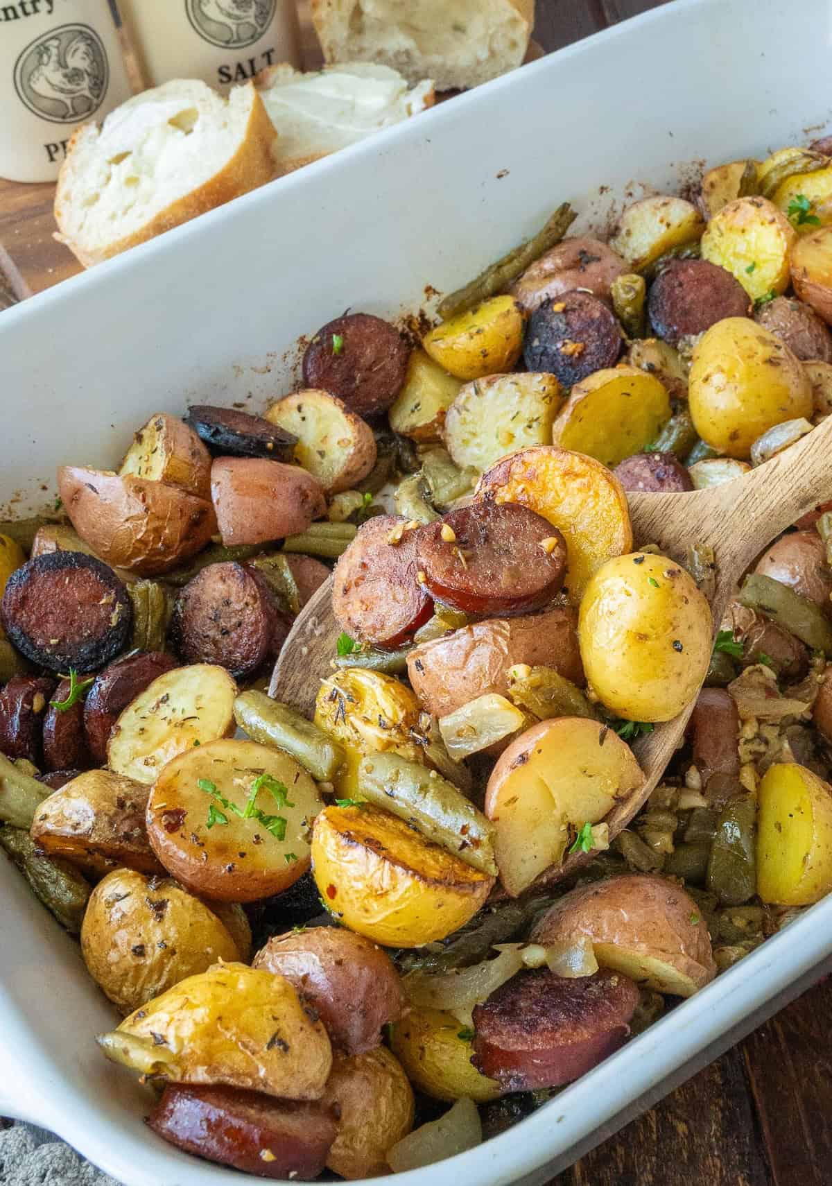 A wooden spoon scooping up some potato bake.