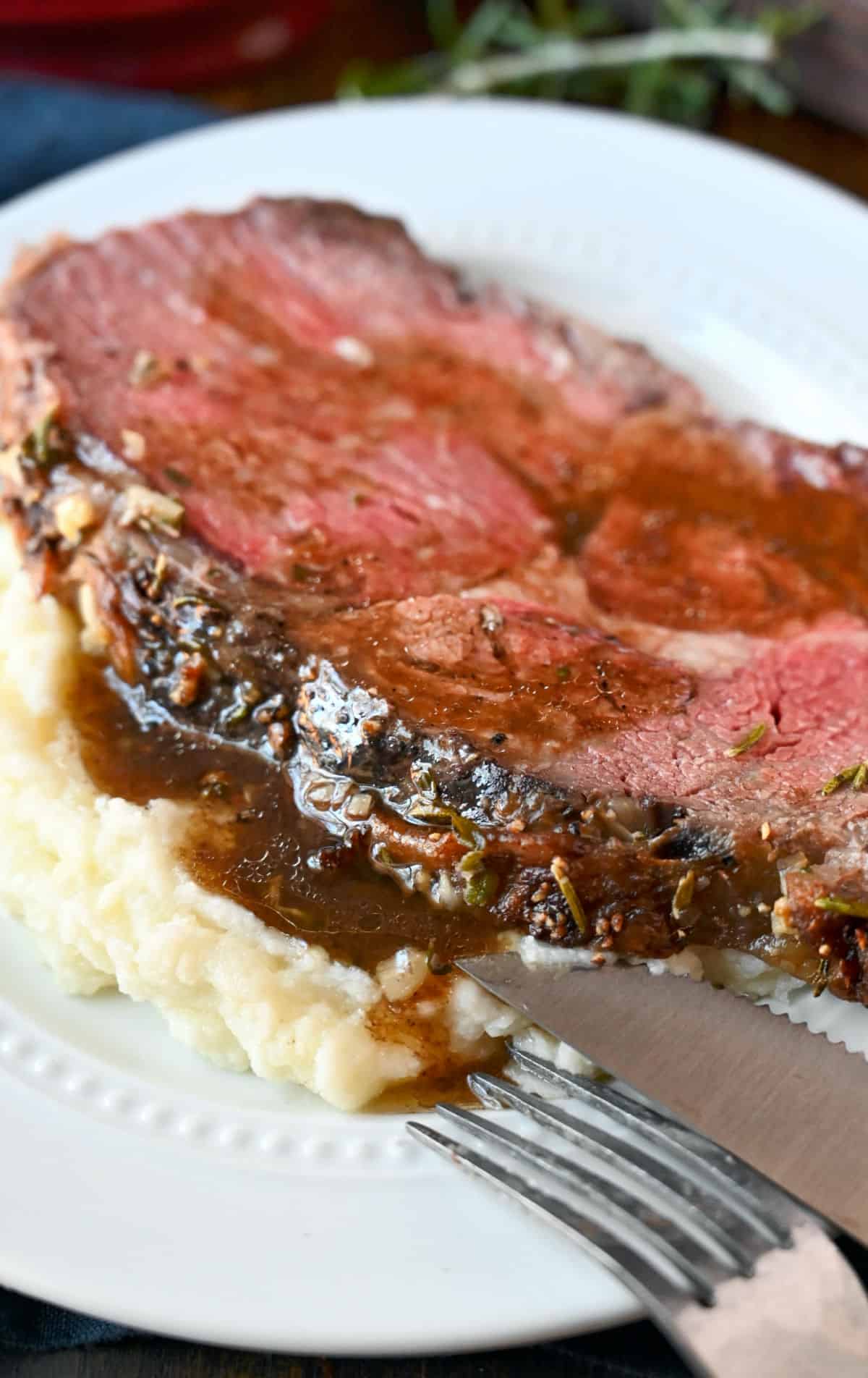 A slice of rib eye on mashed potatoes.