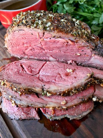 Herb crusted rib eye roast with three thin slices cut out of it.