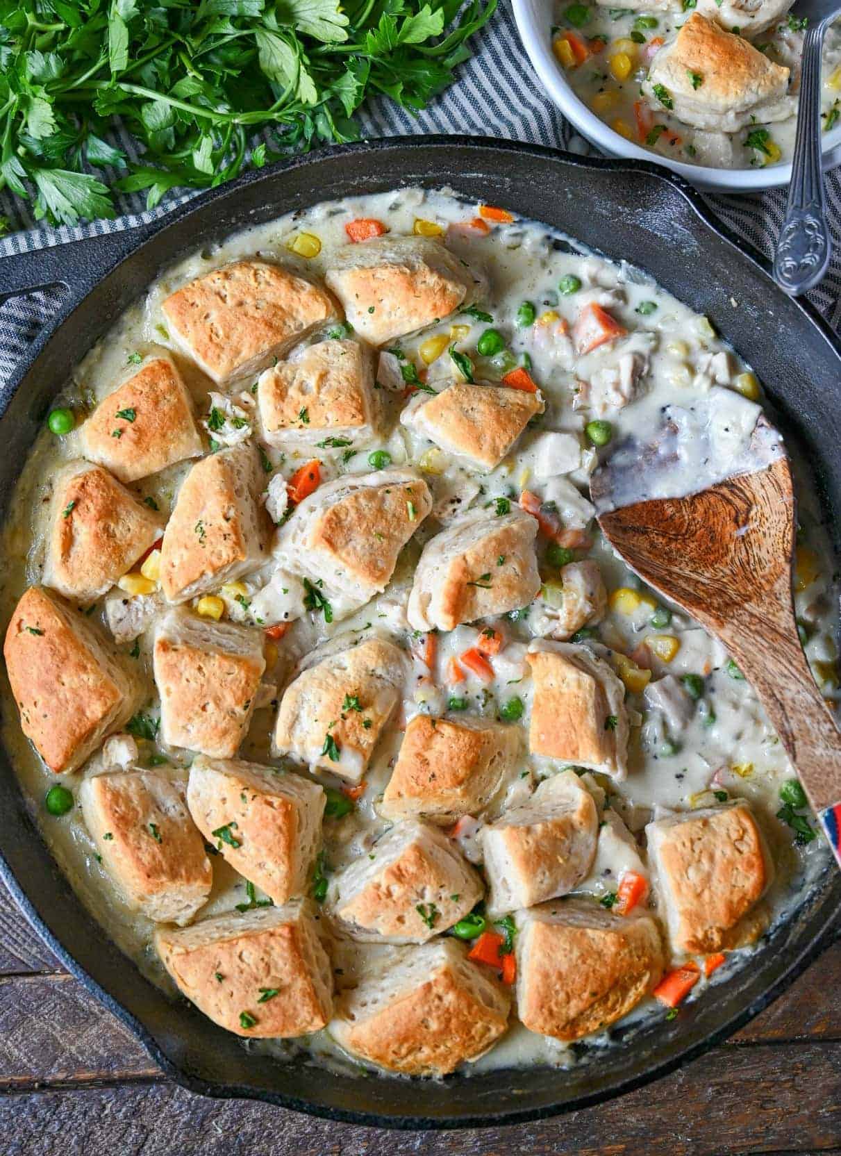 Chicken pot pie in a skillet with biscuits on top.