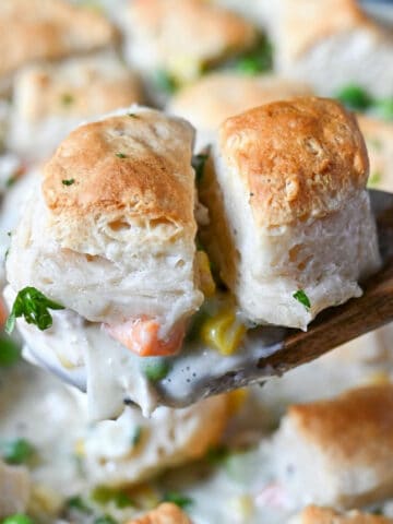 A scoop of chicken pot pie with biscuits on top.