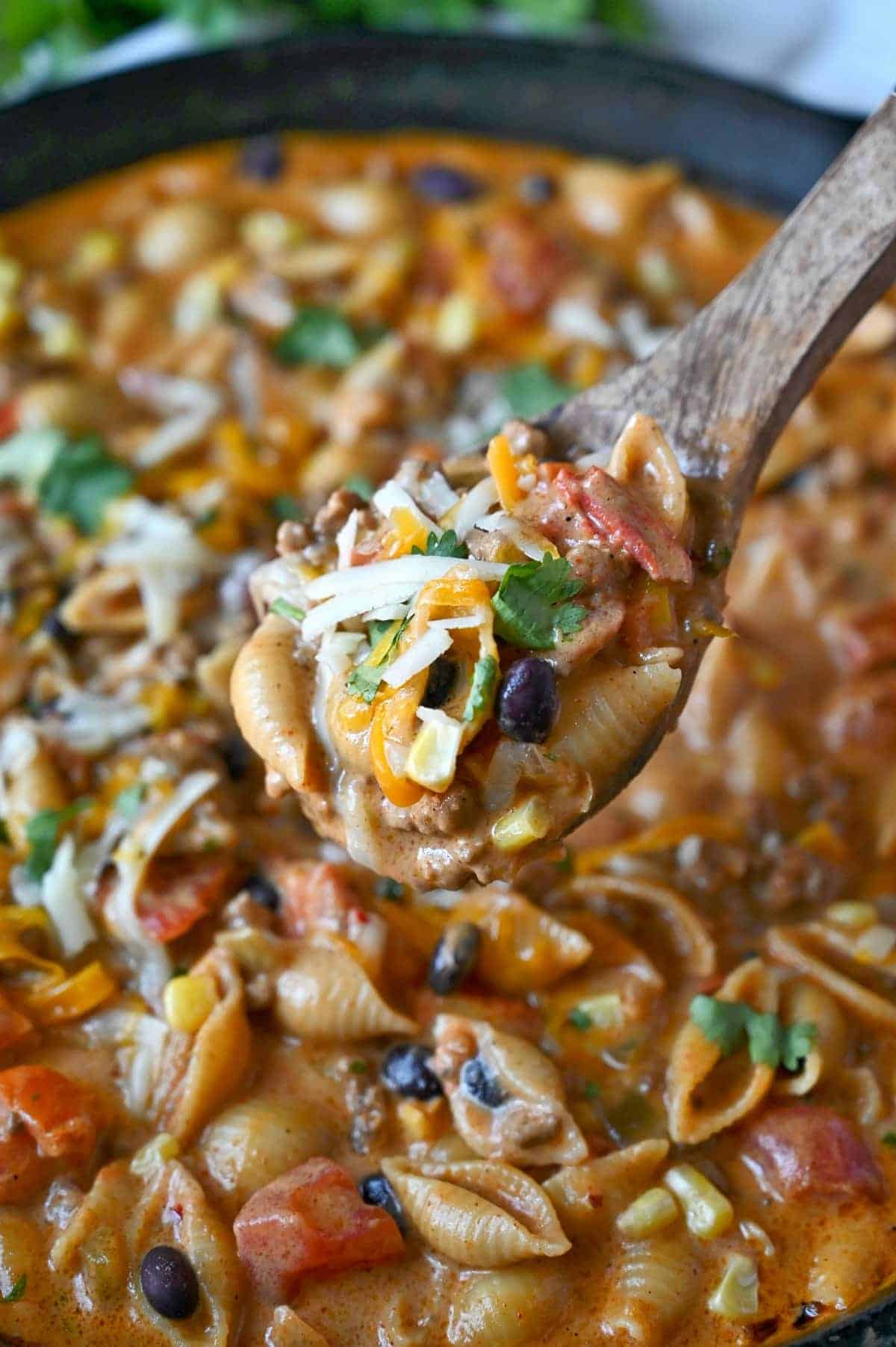 Taco pasta in a large pot with a spoon scooping some out.