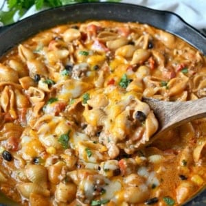 Taco pasta in a cast iron skillet with melted cheese on top.