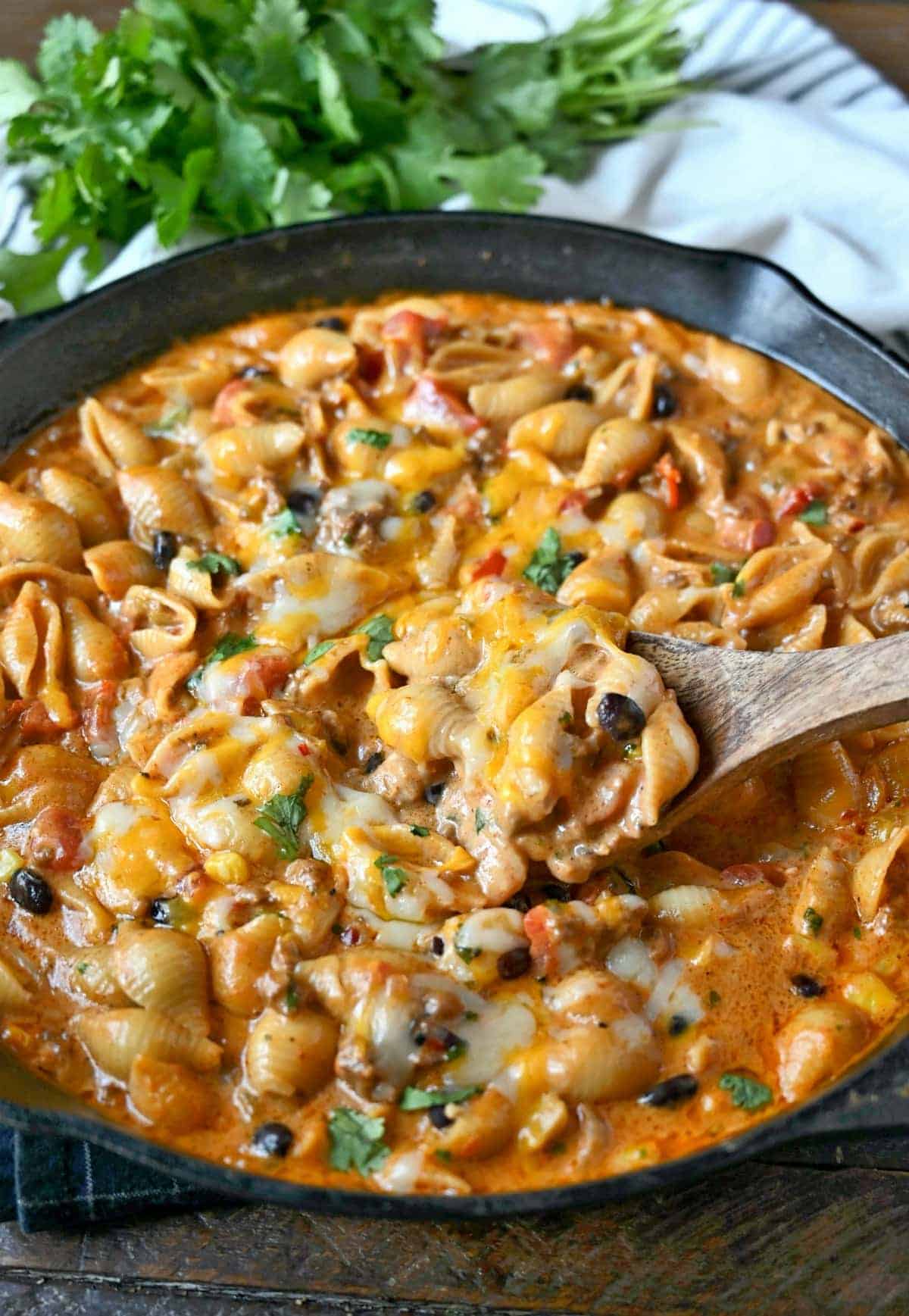 Taco pasta in a cast iron skillet with melted cheese on top.