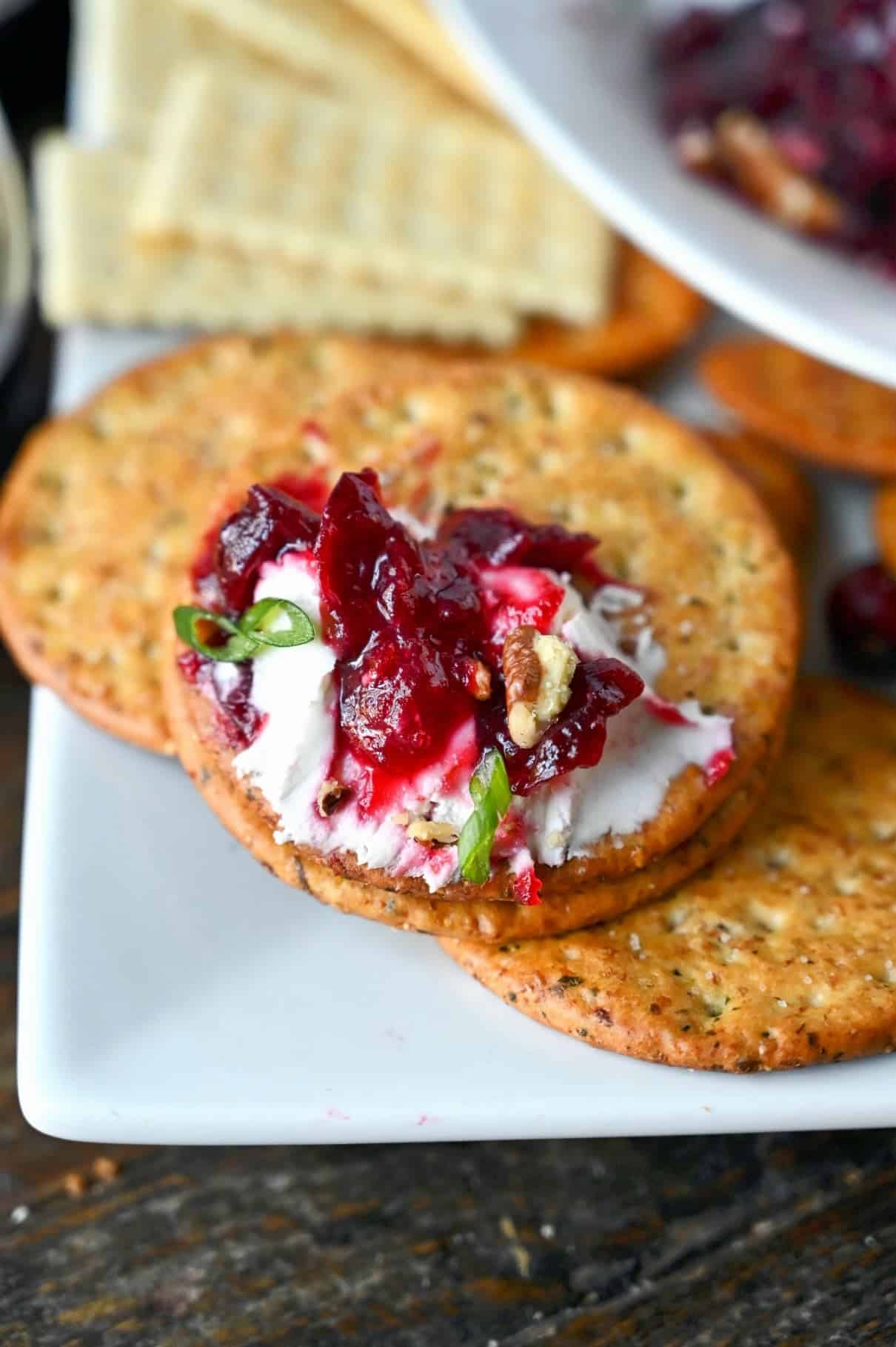 Close up photo of some cranberry cream cheese dip on a cracker.