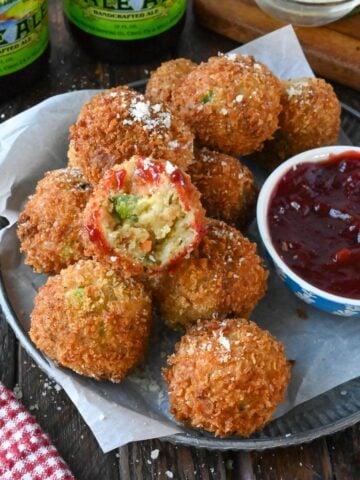 Deep fried stuffing balls on a plate with a bite out of one.