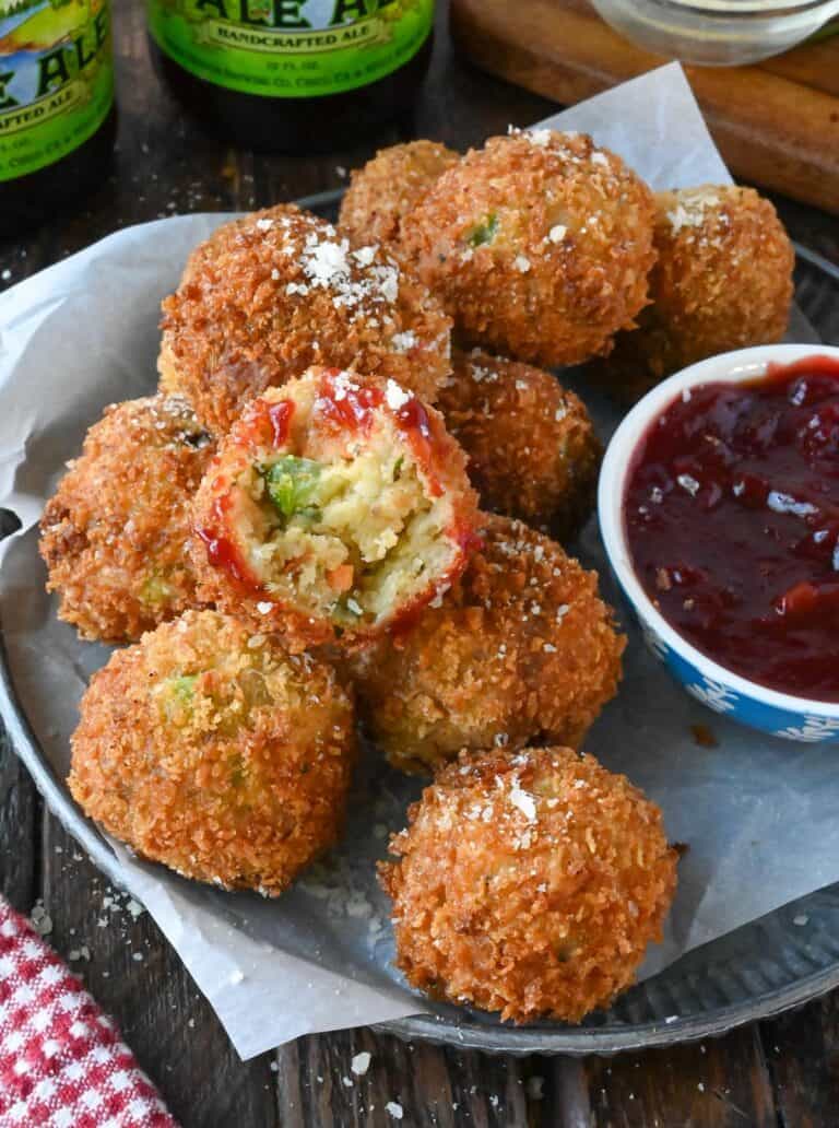 Deep fried stuffing balls on a plate with a bite out of one.