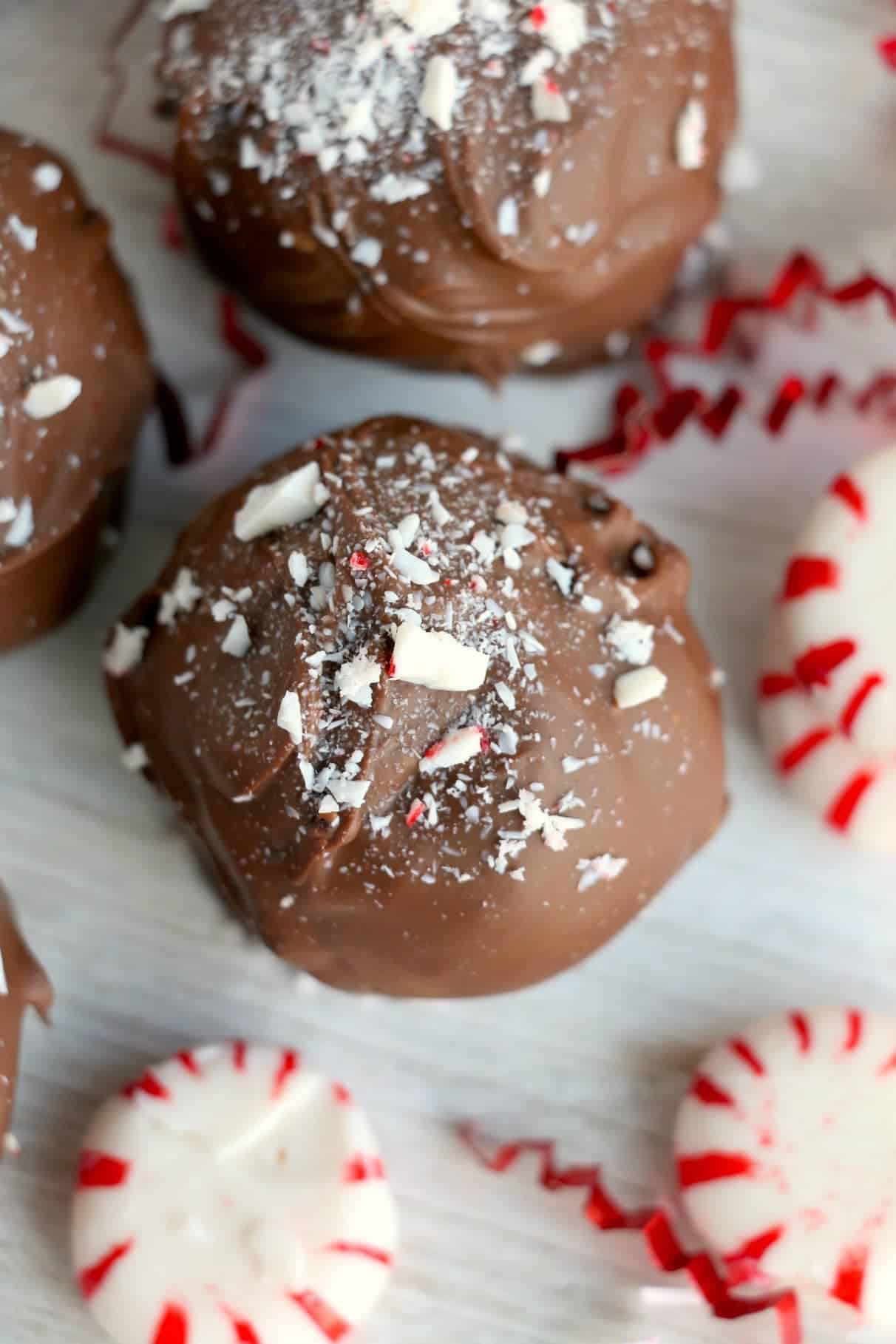 Chocolate-covered cake ball with crushed peppermints on top.