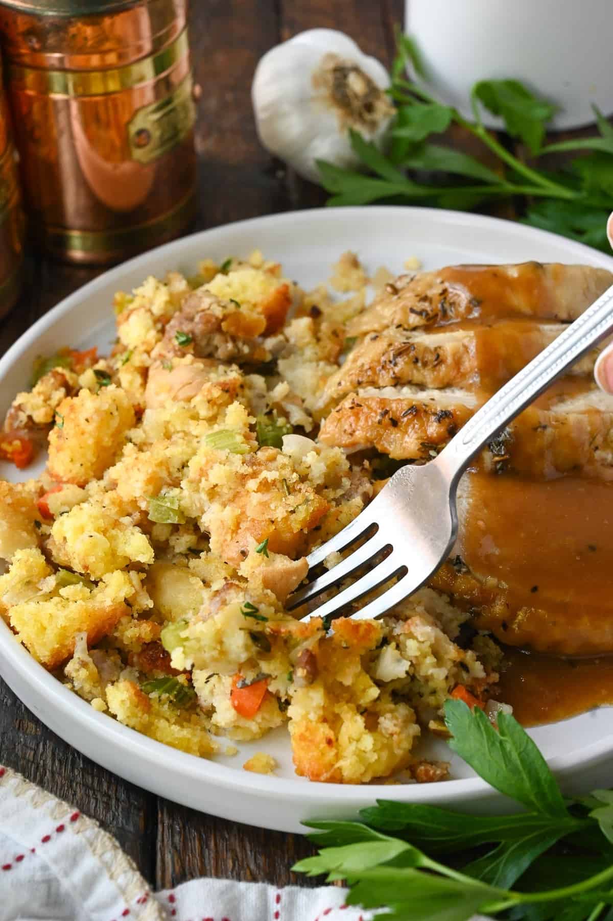 Cornbread dressing on a plate with turkey and gravy.