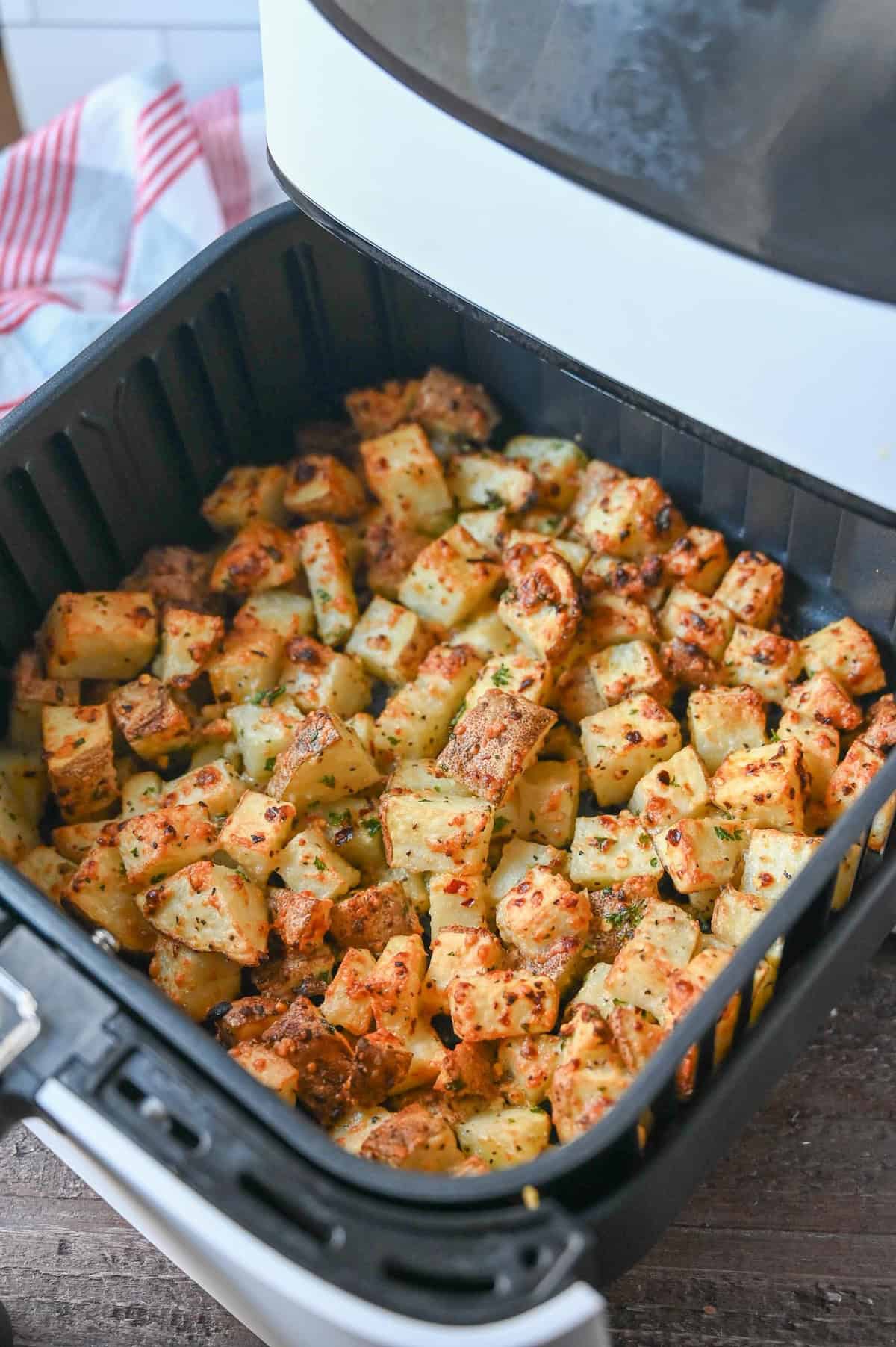 Crispy air fryer potatoes in an air fryer basket.