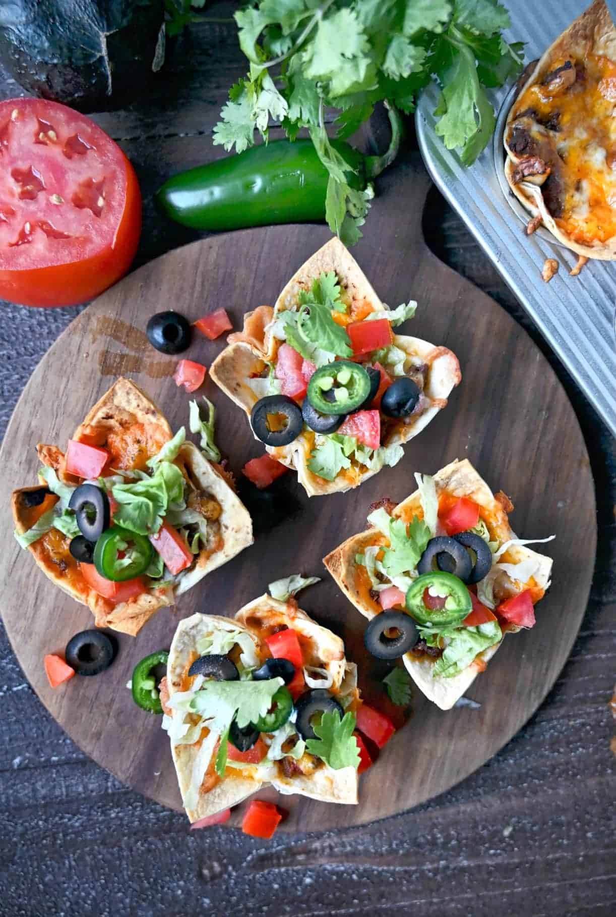 Four taco cups on a cutting board.