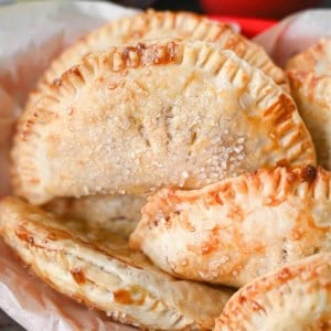 Close up photo of several different hand pies in a red plastic basket.