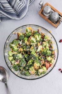 Broccoli salad in a clear glass bowl.