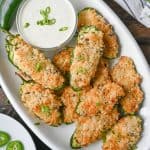 Jalapeno poppers on a white oval plate with a side of ranch dressing.