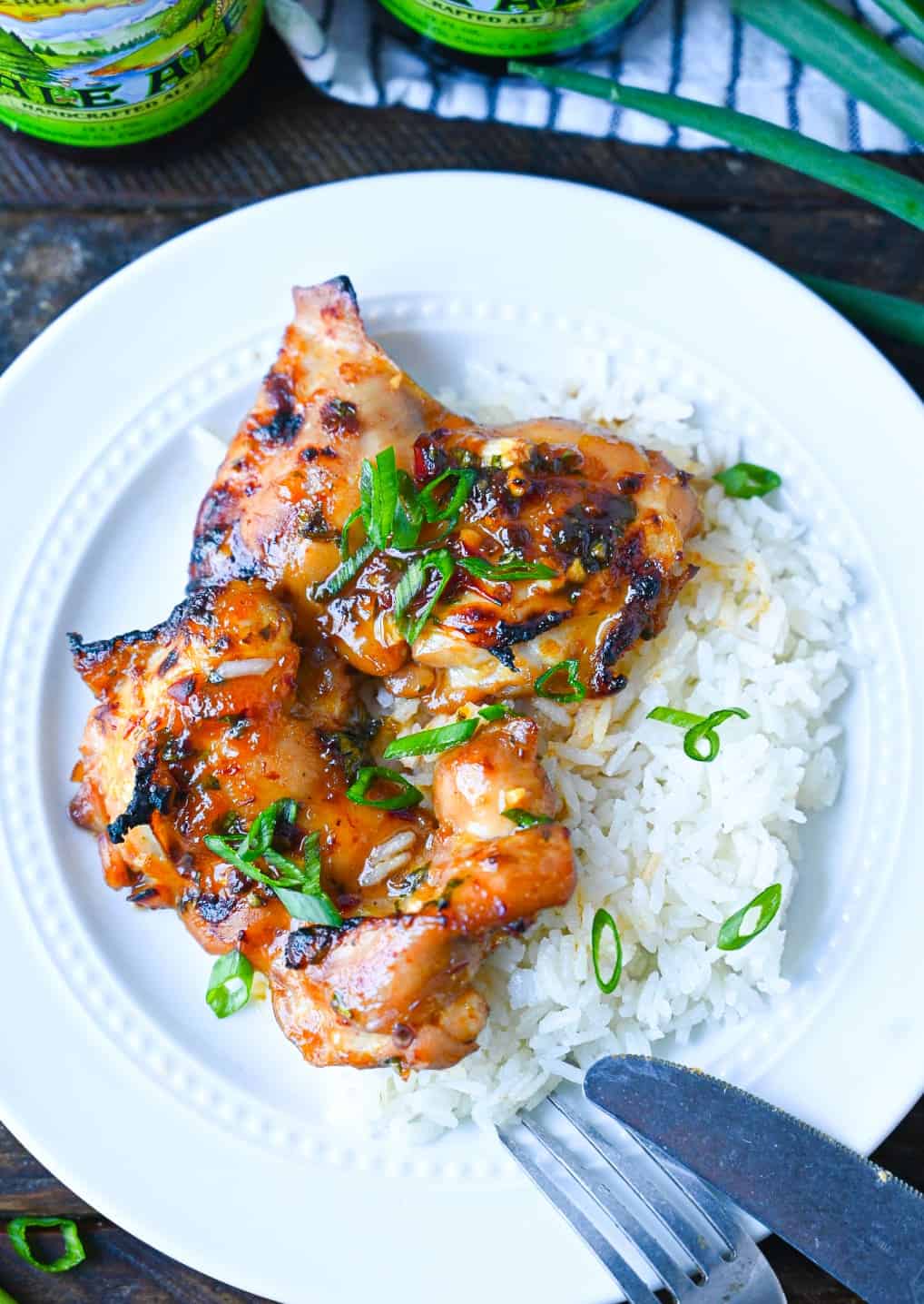 Peach chipotle chicken on top of coconut rice and sliced green onions on top.