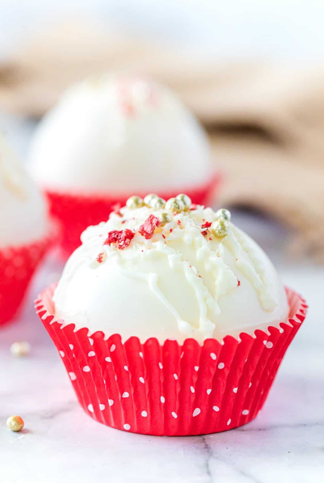 Strawberry hot cocoa bomb in a red cupcake wrapper.
