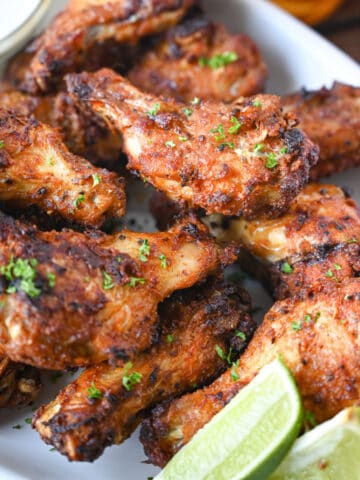 A close up photo of air fryer old bay chicken wings on a white platter.