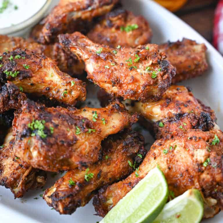 A close up photo of air fryer old bay chicken wings on a white platter.