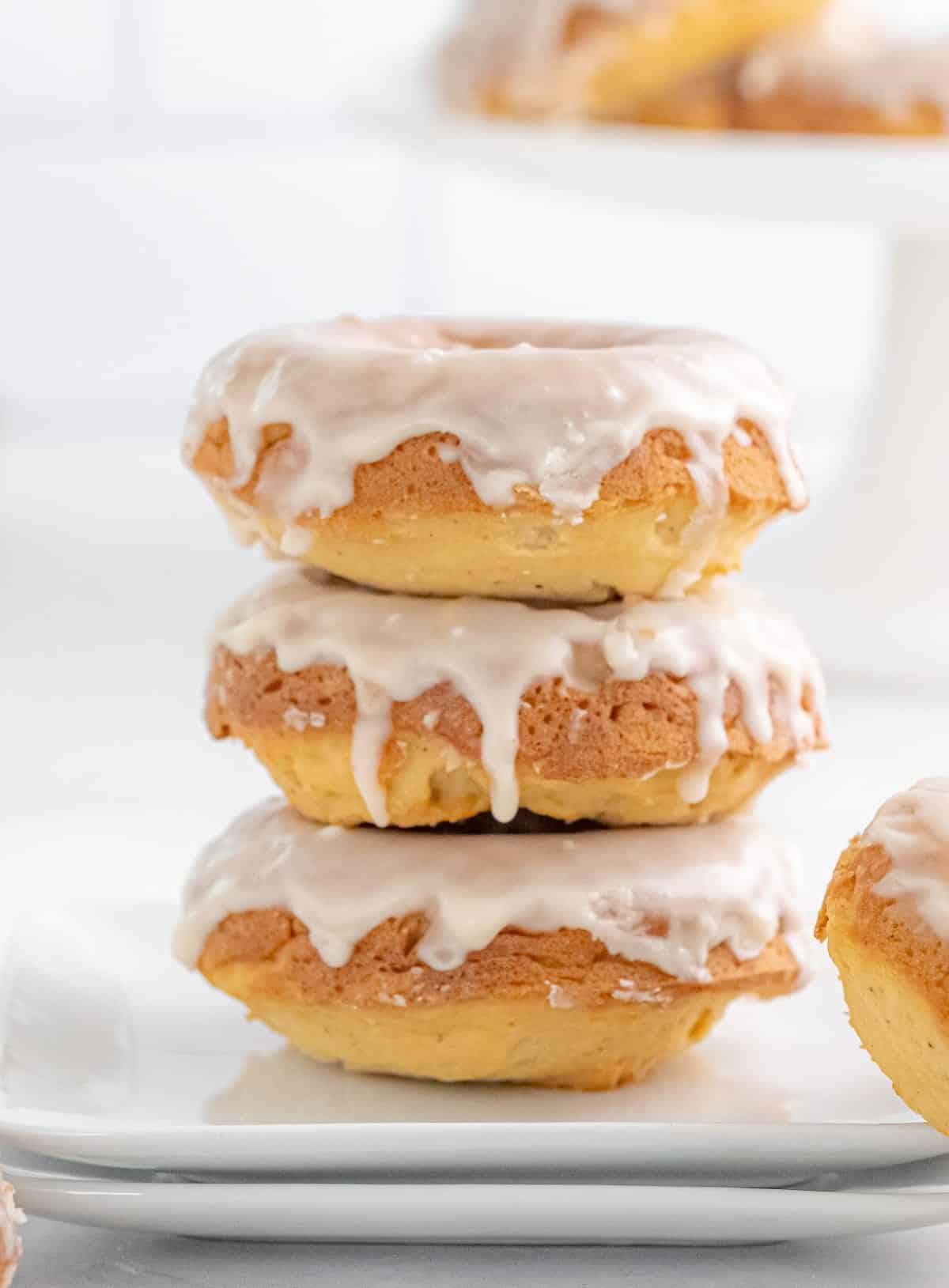 Three baked glazed donuts stacked on top of each other.