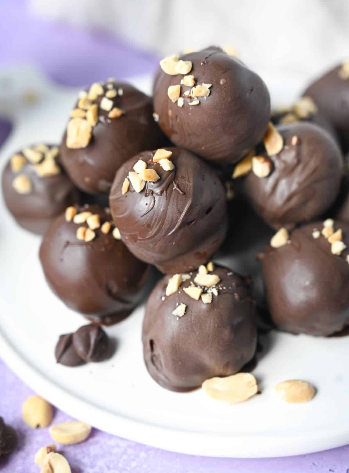 A pile of peanut butter balls on top of each other on a white plate