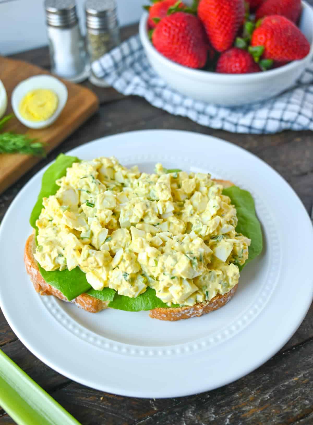 Egg salad spread over lettuse and a slice of bread.