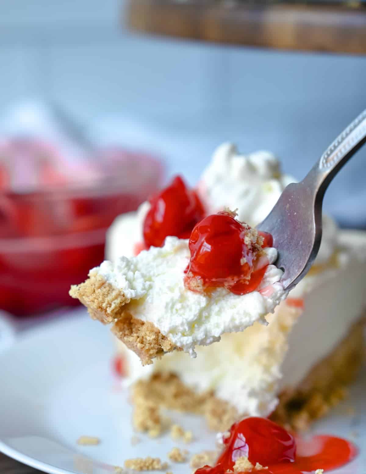 A fork picking up a bite of no bake cheesecake.