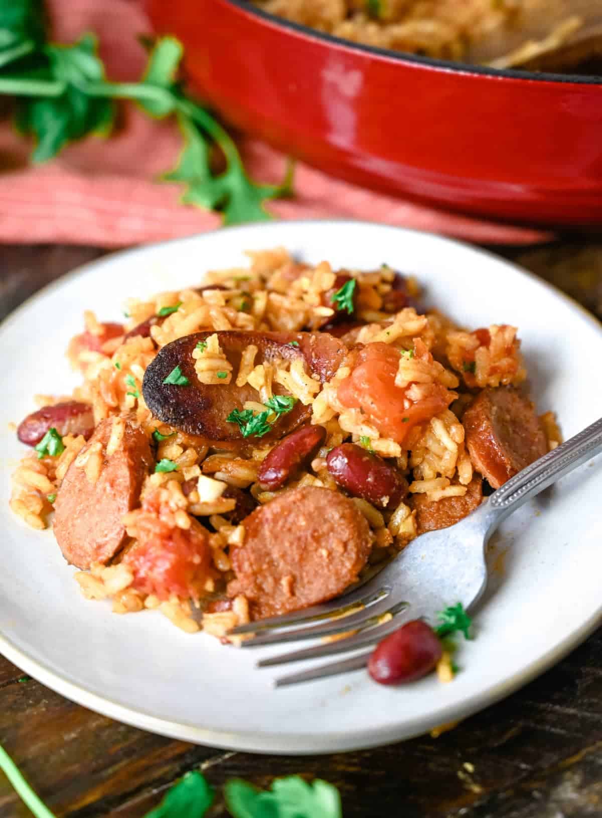 Cajun rice and beans serving on a white plate with a fork.
