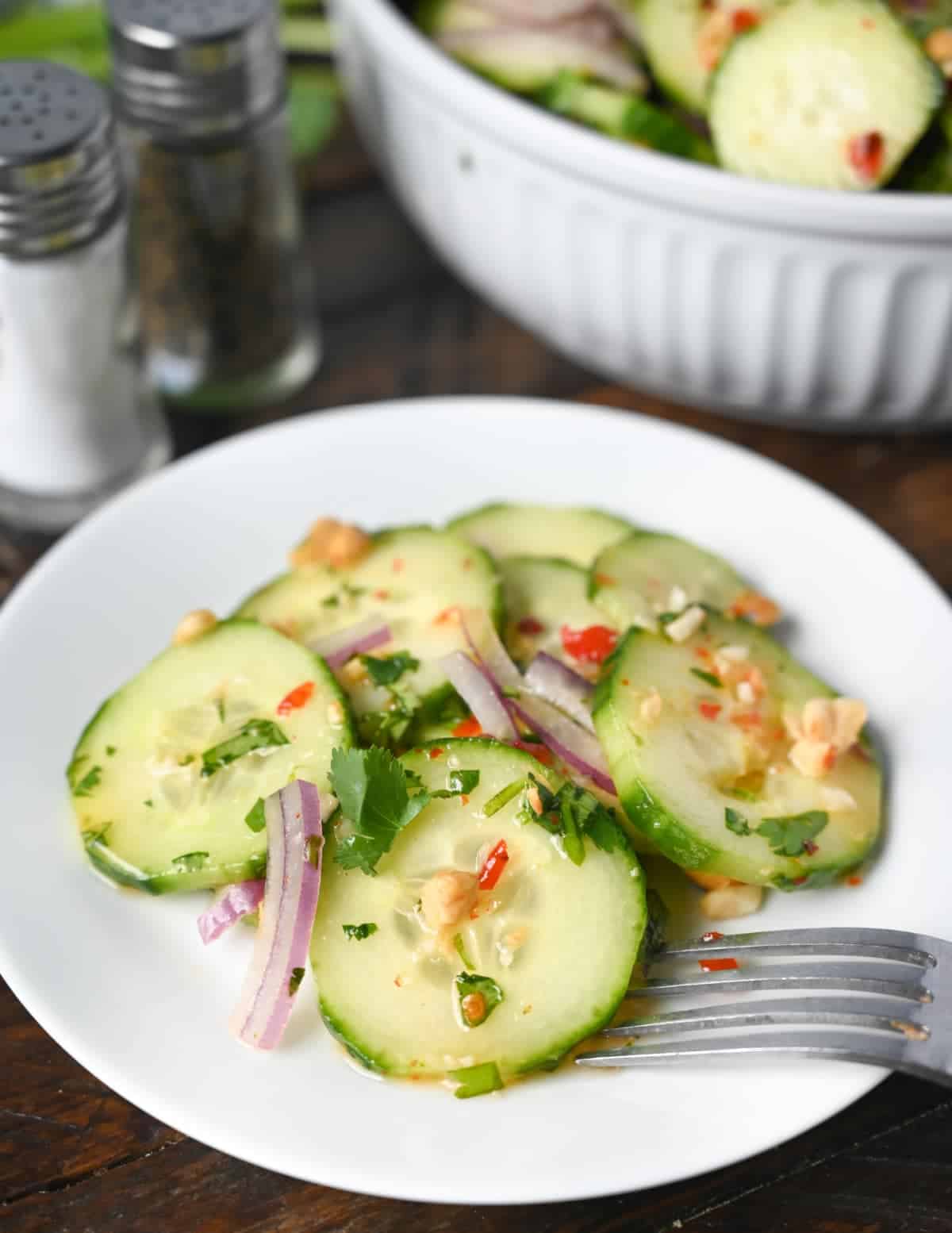 Thai cucumber salad placed on a plate with a fork.