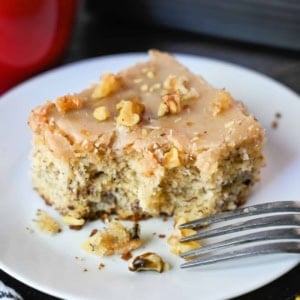 A piece of banana cake on a plate with a fork