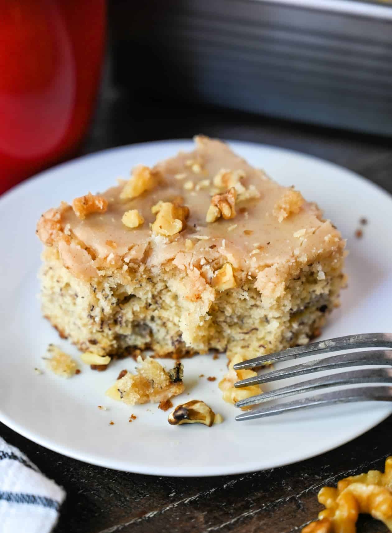 A piece of banana cake on a plate with a fork