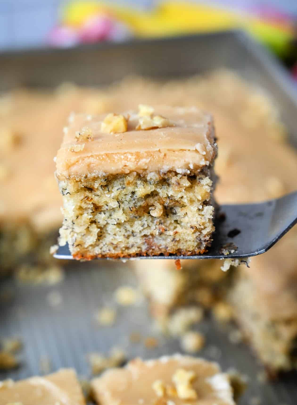 A piece of cake being picked up with a metal spatula.