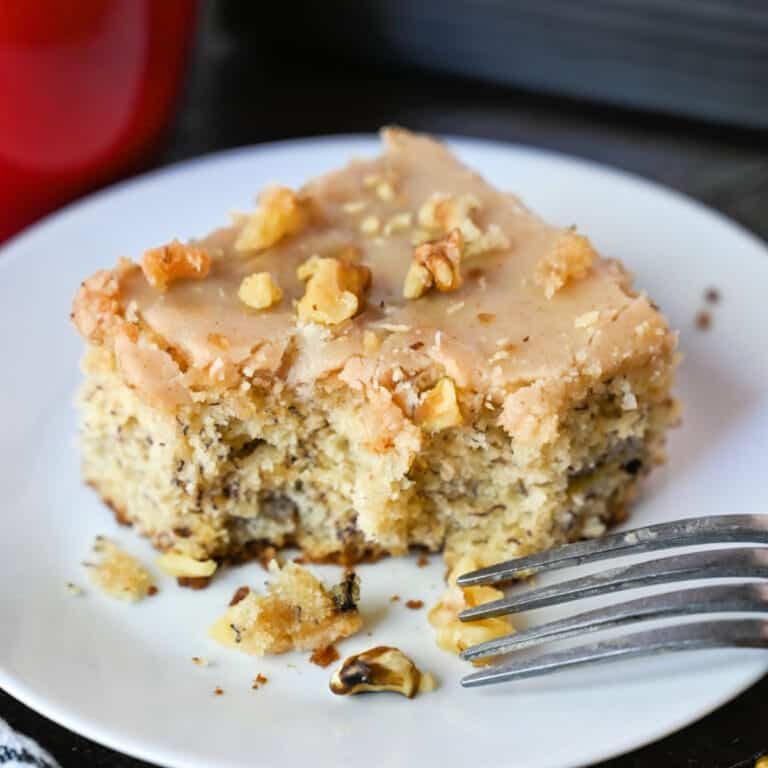 A piece of banana cake on a plate with a fork, 
