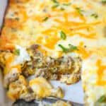 ABreakfast casserole in a white baking dish with a couple servings missing.