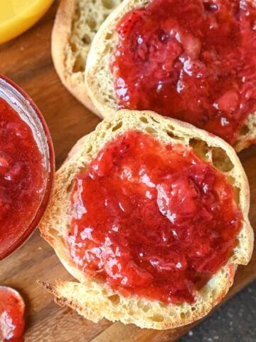 Strawberry jam spread onto english muffin.