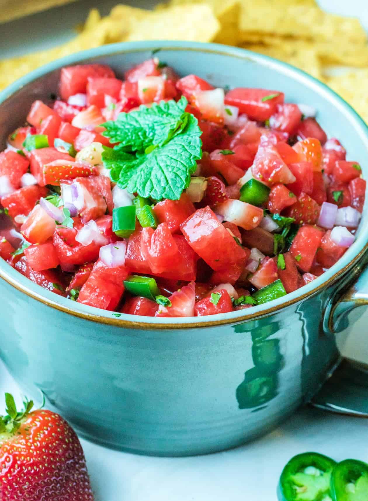 Watermelon salsa in a small teal bowl with a handle.