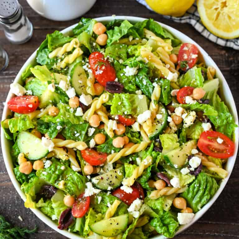 A bowl of food on a plate, with Salad