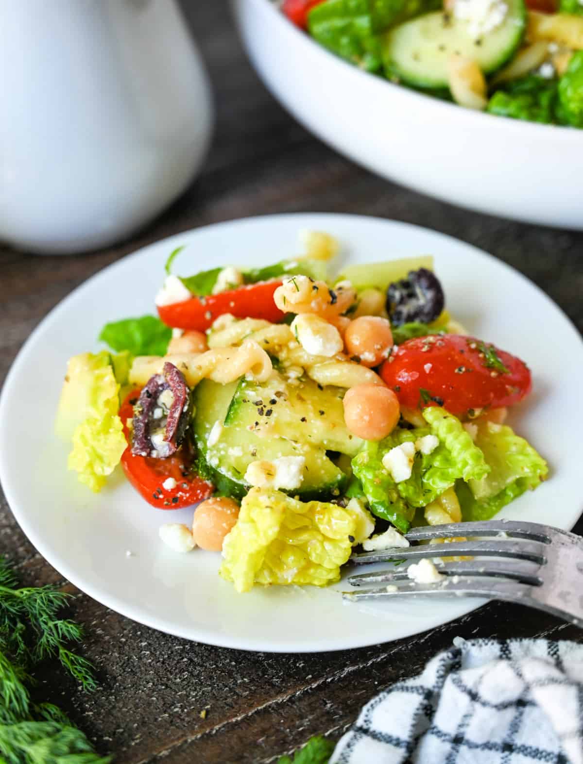 Chopped greek salad on a small white salad plate.