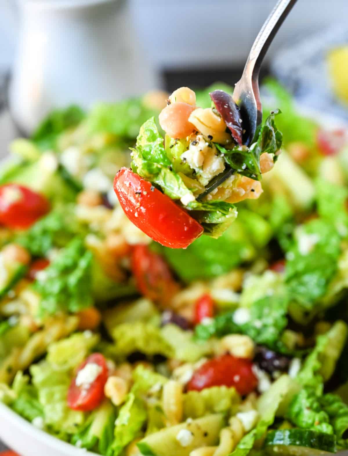 Chopped greek salad bite picked up with a fork.