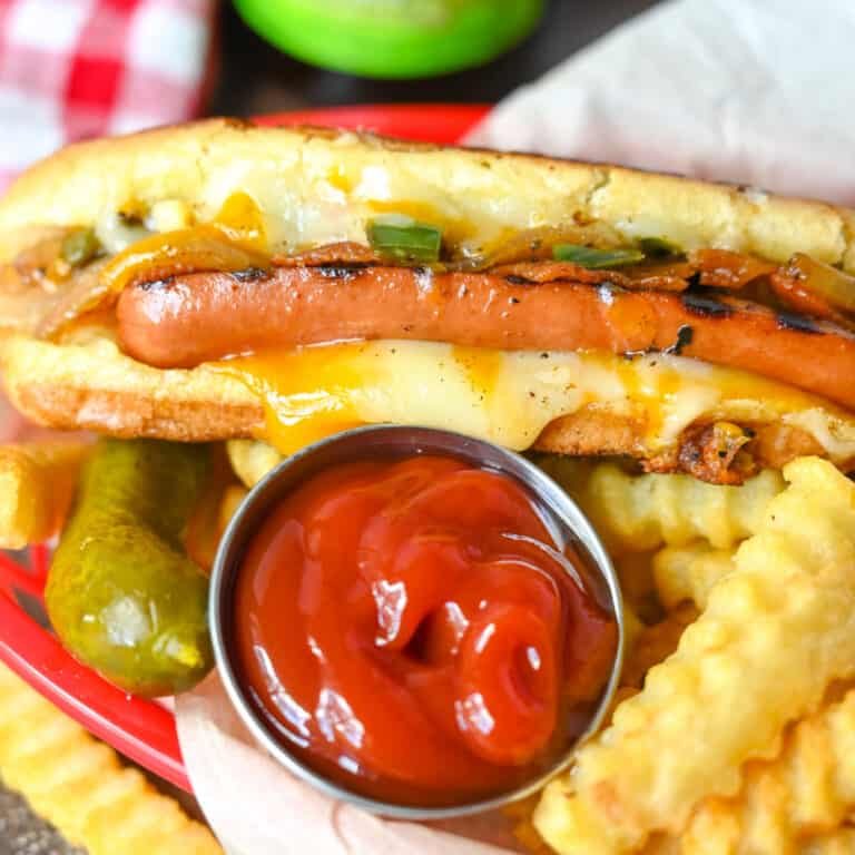 A close up of a plate of food with a hot dog, with Cheese