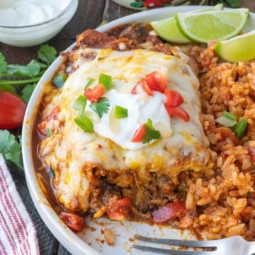 Ground beef enchiladas on a plate with a fork.